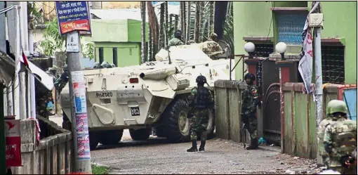  ??  ?? Collateral damage Commandos using an armoured vehicle to fight militants in Bangladesh’s northeaste­rn city of Sylhet. Two ‘powerful’ blasts went off about 400m from the militants’ hideout, targeting a huge crowd of people and police officers who were...