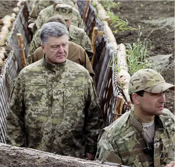 ??  ?? In trincea Il presidente ucraino Petro Poroshenko visita le fortificaz­ioni lungo il fronte di Mariupol, Ucraina dell’Est