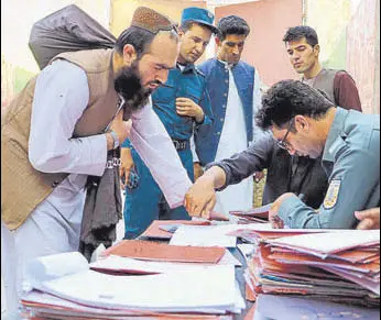  ?? AFP ?? TIME TO GO: Policemen register Taliban prisoners as they are in the process of being released from the Pul-e-charkhi prison on the outskirts of Kabul, Afghanista­n.