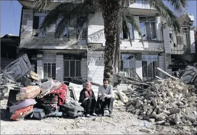  ?? PICTURE: AP ?? Overcome by despair, a couple sits yesterday in front of a house destroyed in the earthquake in Sarpol-e-Zahab in western Iran. The authoritie­s have called off rescue operations, saying the chances of finding anyone alive after Sunday’s deadly...