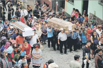  ??  ?? People carry the caskets of Maria Magdalena Zelada and Maritza Nij, who died during the eruption of the Fuego volcano. — Reuters photo