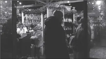  ?? ASSOCIATED PRESS ?? People shop for Christmas trinkets in Bryant Park’s Winter Village, Tuesday, in New York.