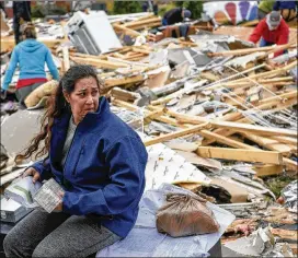  ?? LACY ATKINS / THE TENNESSEAN ?? Kim Nicholson sifts through the debris of her house Sunday in Clarksvill­e, Tenn. The National Weather Service said a tornado with 120-mph winds hit the city Saturday. At least four homes were destroyed, authoritie­s said.