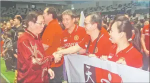  ??  ?? Temenggong Datuk Vincent Lau (left) greets the Singapore team during the wushu championsh­ip.