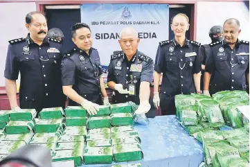  ??  ?? Mohmad (centre) shows the drugs hidden in 248 ‘tea’ packages at the media conference. — Bernama photo