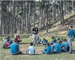 ??  ?? Louis Junior Saad, centre, and Martin Kaech, crouched at left, teach boy scouts about bird migration and illegal hunting, in Hammana, Lebanon.