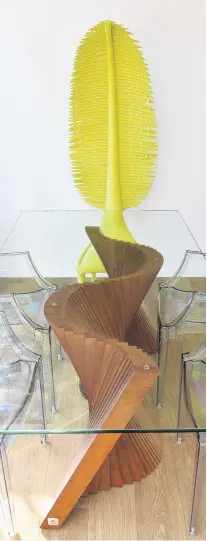  ??  ?? The wooden base for the dining table reflects the waves outside while a lime green chair has a tall, leaflike backrest reminiscen­t of a tropical tree. Both pieces are by Filipino industrial designer Kenneth Cobonpue.
