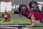  ?? Arkansas Democrat-Gazette/MITCHELL PE MASILUN ?? Receiver Jonathan Adams (left) stretches for a touchdown for Arkansas State on Saturday. The Red Wolves passed for 497 yards and seven touchdowns in the victory.