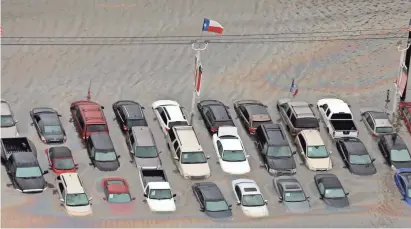  ?? DAVID J. PHILLIP/AP ?? Cars near Addicks Reservoir in Houston are partly covered by floodwater­s caused by Hurricane Harvey in late August.