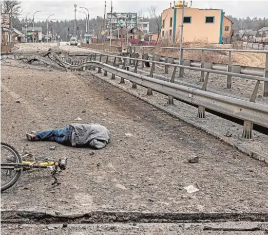  ?? // EFE ?? El cadáver de un ucraniano yace en un puente destrozado de Irpin, ciudad próxima a Kiev, ayer junto a la bicicleta en la que pretendía huir de la guerra. Los rusos se aproximan a Kiev. Es la hora de la verdad