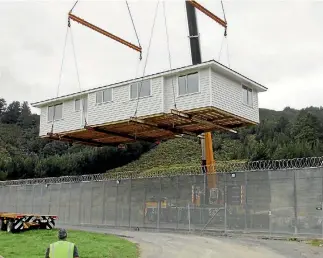  ?? PHOTO: SUPPLIED ?? A house built by eight prisoners is lifted over the wire at Upper Hutt’s Rimutaka Prison. It will be used as a state house in Lower Hutt.