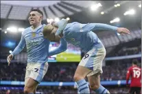  ?? MIKE EGERTON — PA VIA AP ?? Manchester City’s Erling Haaland, right, celebrates with teammate Phil Foden, after scoring his side’s third goal during the English Premier League match against Manchester United at the Etihad Stadium in Manchester, England on Sunday.