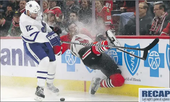  ?? GETTY IMAGES ?? Connor Murphy of the Blackhawks hits the wall after chasing the puck with Maple Leafs winger Patrick Marleau last night at the United Center in Chicago. The Leafs pulled out a 3-2 overtime win on William Nylander’s penalty-shot goal.
