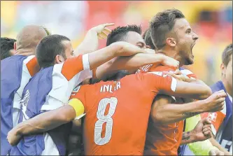  ?? MICHAEL SOHN/AP PHOTO ?? Haris Seferovic of Switzerlan­d, right, is mobbed by teammates after scoring the tie-breaking goal in the final minute of a 2-1 win over Ecuador in a World Cup game Sunday at Brasilia, Brazil.