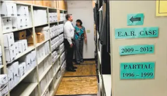  ?? FBI ?? FBI Special Agent Marcus Knutson and Sacramento County Sheriff ’s Department Deputy Paige Kneeland work on the East Area Rapist case in the Sheriff ’s Department evidence room.
