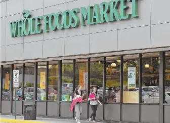  ?? STAFF PHOTO, ABOVE, BY PATRICK WHITTEMORE; AP PHOTO, TOP ?? A MARKET FOR MARKETS: More than 430 Whole Foods Market stores, including this one in Charlestow­n, above, are expected to be owned by Amazon.com Inc. by year’s end. Top, news of the deal had traders busy yesterday at the New York Stock Exchange.