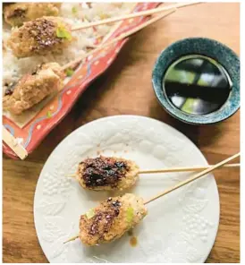  ?? GRETCHEN MCKAY/PITTSBURGH POST-GAZETTE ?? Chicken skewers with a salty-sweet yakitori sauce are simmered in water before being glazed on the grill.