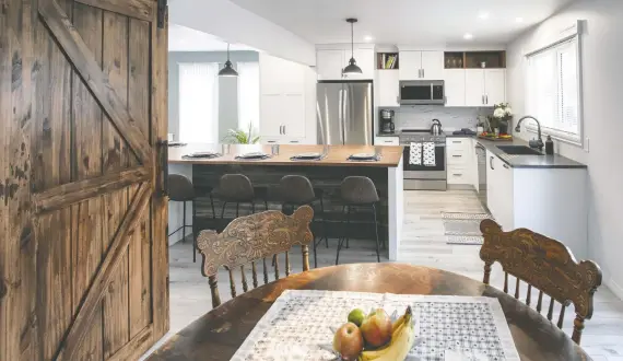  ?? ?? Centennial Kitchen & Bath won a 2024 Housing Excellence Award for best kitchen renovation (over $50,000) for this farmhouse style kitchen. After inheriting the property, the homeowners sought to retain mementoes while achieving a stylish kitchen that fit their lifestyle. Among the design details is the use of barn wood sourced from the designer's family farm.