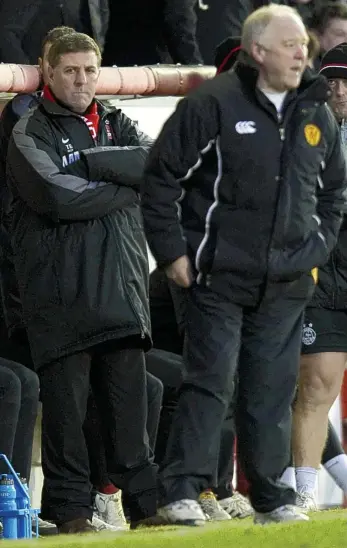  ??  ?? Grim-faced: McGhee looks on as Aberdeen lose to Craig Brown’s Motherwell in 2010