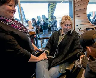  ?? PHOTO: DAVID WALKER/FAIRFAX NZ ?? Giselle Lea, left, and daughter Jamilia got matching semicolon tattoos from Josh Waretini, at the Barbers Ink fundraisin­g event in Christchur­ch on Saturday.