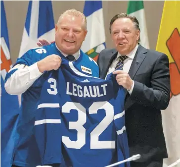  ?? PHOTO REUTERS ?? Le premier ministre ontarien, Doug Ford, a remis un chandail de hockey aux couleurs des Maple Leafs au premier ministre du Québec, François Legault, hier, à Toronto.