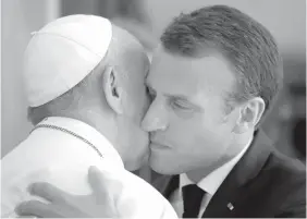  ?? AGENCE FRANCE PRESSE ?? French President Emmanuel Macron hugs Pope Francis at the end of a private audience at the Vatican.