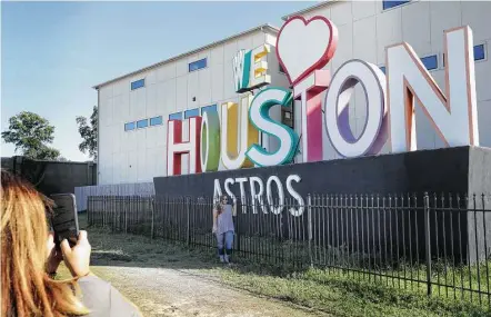  ?? Jon Shapley / Houston Chronicle ?? Leanne Searcey, left, takes a photo on Monday of her niece, Brittney, by a sign along Interstate 10, that was modified to read, “We (heart) Houston Astros.” Efforts to keep the city safe during the World Series are ramping up.