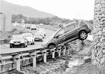  ??  ?? Cars and debris are seen on a road after the heavy rain and flash floods in Sant Llorenc de Cardassar, Spain. — Reuters photo