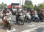  ?? AHMAD KHUSAINI/JAWA POS ?? BELUM MAKSIMAL: Garis physical distancing di perempatan Jalan Karang Tembok tak berhasil membuat pengendara patuh.