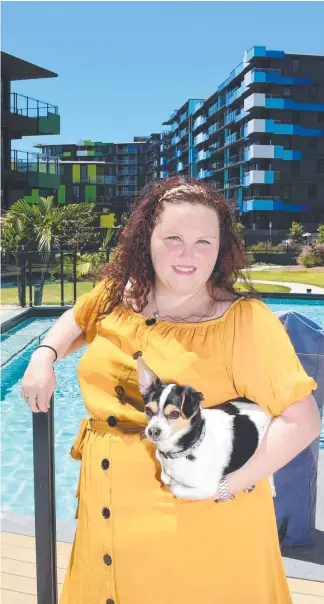  ?? Picture: STEVE HOLLAND ?? Nurse Georgia Johnson and her dog Duke are among the first to move into the Smith Collective, the former Commonweal­th Games Village.