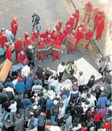  ?? /Antonio Muchave ?? In need of a
home: The Red Ants oversee evictions in the Joburg CBD. The metro council and NGOs representi­ng poor residents are at odds over an act that will bring relief to property owners.