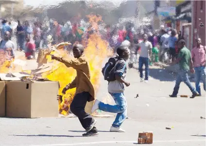  ?? Picture: AFP ?? FACE-OFF. Opposition supporters set up a burning barricade in skirmishes with police during a protest march for electoral reform yesterday in Harare.