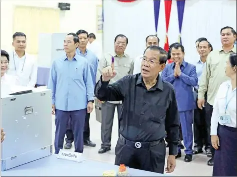  ?? ?? Former Prime Minister Hun Sen, who is standing for Senate president, holds his freshly inked finger up after casting his ballot for the Senate election, in a voting station in Kandal province’s Takhmao town, just outsides the capital, on February 25.