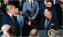  ?? Andrew Harnik / Associated Press ?? President Donald Trump, left, gave manager A.J. Hinch a turn at his East Room podium during the Astros’ visit on Monday.