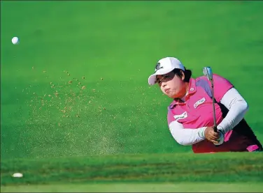  ?? HARRY HOW / GETTY IMAGES / AFP ?? World No 1 Feng Shanshan blasts out of a bunker on the 12th hole during Wednesday’s opening round of the LPGA Lotte Championsh­ip at Ko Olina Golf Club in Kapolei, Hawaii. The Chinese star shot a 5-under 67 to top the leaderboar­d.