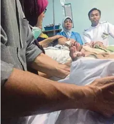  ??  ?? MOHD Nazri menatap wajah Siti Sarah di atas katil di Hospital Melaka, semalam.