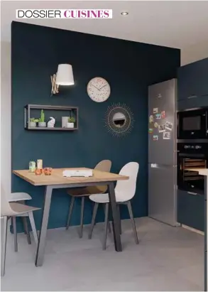  ??  ?? Ci-contre. Pour créer un espace de vie harmonieux et convivial, le coin repas est coordonné à la cuisine ! On aime la touche métal apportée par la niche et le piétement design. Le Bleu nocturne mat crée un effet «cosy». Ultra tendance, il apporte une alternativ­e plus douce au noir. Socoo’c