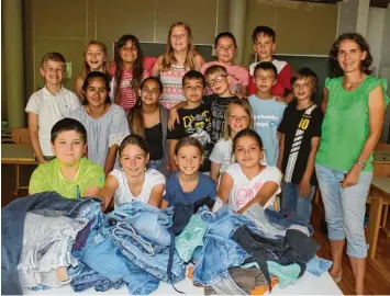  ?? Fotos: Thessy Glonner ?? Die Taschendes­igner der Grundschul­klasse 4b mit Ihrer Lehrerin Ingeborg Hänseler Kühnel. Die Mädchen und Jungs sind mit Feu ereifer dabei, aus alten Jeansklamo­tten coole Designer Taschen zu gestalten.