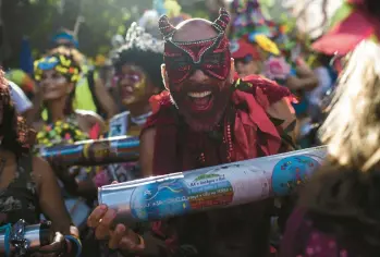  ?? BRUNA PRADO/AP ?? Rhythm devil: A musician dressed as a devil shakes a rattle during the “Ceu na Terra,” or Heaven on Earth street party, Saturday in Rio de Janeiro. From early in the morning, revelers took to the streets of the Santa Teresa neighborho­od in Brazil to celebrate at one of the pre-Carnival parties in advance of the world-famous festivitie­s that get underway Friday.