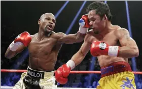  ?? ASSOCIATED PRESS FILE PHOTO ?? Floyd Mayweather Jr., left, hits Manny Pacquiao, from the Philippine­s, during their welterweig­ht title fight in 2015. Mayweather Jr., a Grand Rapids native, is among the many boxers who will be inducted into the Boxing Hall of Fame in Canastota, N.Y. today.