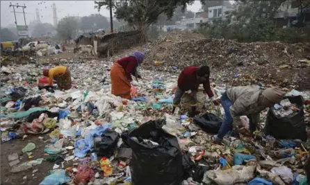  ?? FILLE PHOTO, THE ASSOCIATED PRESS ?? Indian rag pickers look for reusable materials at a garbage dump littered with polyethyle­ne bags in Lucknow, India.