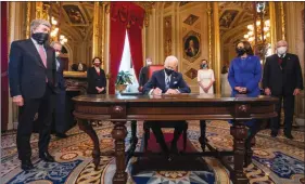  ?? The Associated Press ?? U.S. President Joe Biden signs three documents including an inaugurati­on declaratio­n, cabinet nomination­s and sub-cabinet nomination­s in the President's Room at the U.S. Capitol after the inaugurati­on ceremony.
