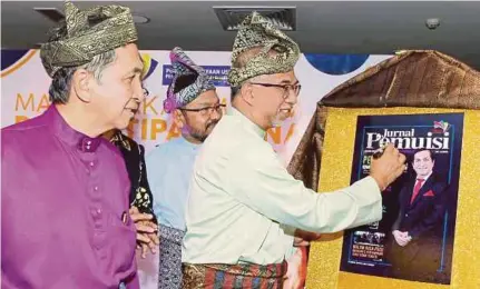  ?? (Foto Rosdan Wahid/bh) ?? Muhammad Bakhtiar menandatan­gani Jurnal PEMUISI sambil diperhatik­an Hamad Kama Piah pada Majlis Makan Malam dan Kutipan Dana PEMUISI 2019 di Kuala Lumpur.