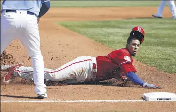  ?? JOE ROBBINS / GETTY IMAGES ?? The Phillies’ Aaron Altherr slides safely into third base with a three-run triple in the fourth inning of Wednesday’s 5-5 tie with the Rays.