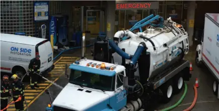  ?? CP PHOTO ?? Firefighte­rs use a water pump truck to help clean up at Surrey Memorial Hospital after it was evacuated due to flooding in the emergency room on Monday.