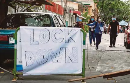  ?? EPA PIC ?? Contact tracers go through a street under lockdown to interview quarantine­d residents following a spike in Covid-19 cases in Quezon City, Metro Manila, on Monday.