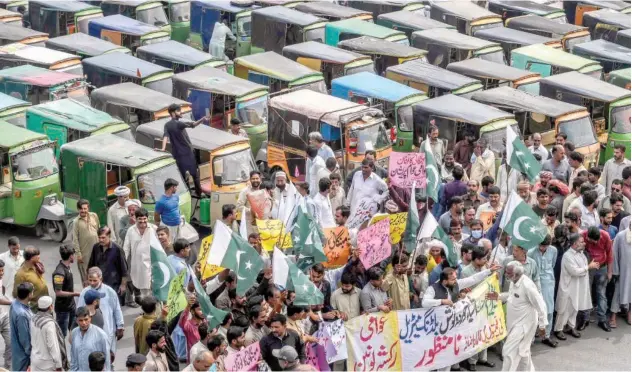  ?? Agence France-presse ?? Autoricksh­aw drivers stage a demonstrat­ion against the rising fuel prices in Lahore on Sunday.