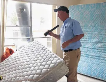  ?? Stephanie S. Cordle McClatchy-Tribune ?? A JURY in San Bernardino County has awarded damages to an Arkansas family who said they suffered bedbug bites at a Rancho Cucamonga hotel in 2013. Above, a pest-control worker inspects a St. Louis home in 2010.