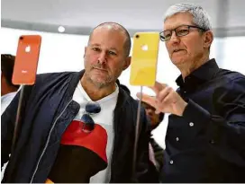  ?? Justin Sullivan/Getty Images/AFP ?? O presidente da Apple, Tim Cook (à dir.), e o diretor de design da companhia, Jony Ive, mexem em modelos coloridos do iPhone Xr