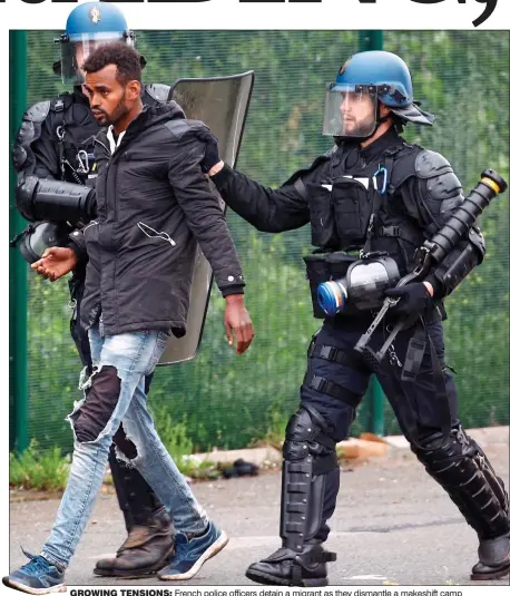  ??  ?? GROWING TENSIONS: French police officers detain a migrant as they dismantle a makeshift camp